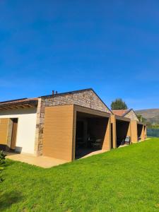 a house with a garage and a green lawn at Las Casitas de Cueva in Cueva