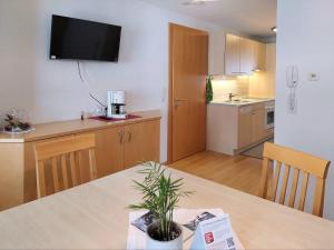 a kitchen with a table and a television on the wall at Appartement Elisabeth in Schoppernau +8 photos