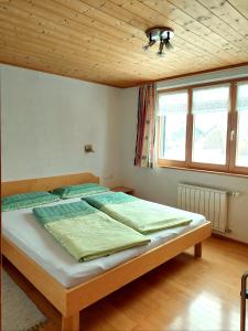 a bedroom with a large bed with a wooden ceiling at Appartement Elisabeth in Schoppernau