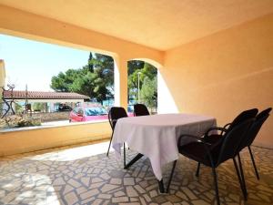 a table and chairs in a patio with a view of a car at House Vale in Jadrija