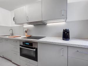 a kitchen with white cabinets and a stove top oven at T2 Cosy à Fegersheim avec balcon & parking privé in Fegersheim