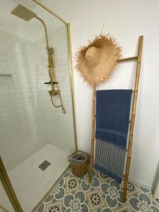 ル・ポルテルにあるLa petite Margotのシャワーと壁に麦わら帽子が掛かったバスルーム +27枚の写真