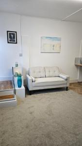 a living room with a white couch in a room at The Studio in Hartlepool +1 photo