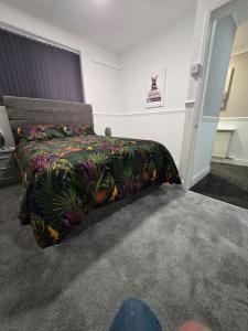 ストックトン・オン・ティーズにあるLevy Nook House 1 bed apartment 5 minute walk to Stockton town centre & Free Parkingのベッドルーム1室(カラフルな掛け布団付きのベッド1台付)