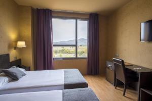 ein Hotelzimmer mit Bett, Schreibtisch und Fenster in der Unterkunft Alda El Espinar in El Espinar + 66 Fotos