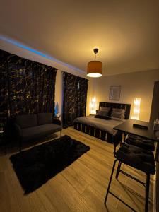 Un dormitorio con una cama, un sofá y una mesa. en Elegant Escape 2, en Bucarest