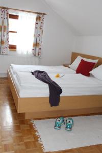 a bedroom with a bed with shoes on the floor at Ferienwohnung Seiringer in Attersee am Attersee