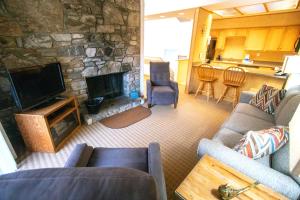 a living room with a couch and a stone fireplace at Fox Run at Lake Lure in Lake Lure