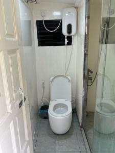 a small bathroom with a toilet and a shower at Rooftop Rooms in Male City