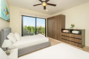 una camera da letto con un letto e un ventilatore a soffitto di Oceanview Pool & Lounge Private Balcony Gym & BBQ a Playa del Carmen