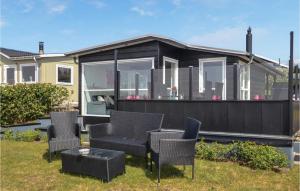 エスビャウにあるFour-Bedroom Holiday Home In Esbjerg Vの庭の椅子とテーブル付き家