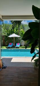 une piscine avec deux chaises et un parasol dans l'établissement Luxury 3 bedroom pool villa, à Laguna Phuket