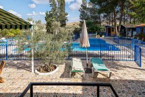 a pool with two lounge chairs and an umbrella at Casa Rural Mi Campo in Fenazar