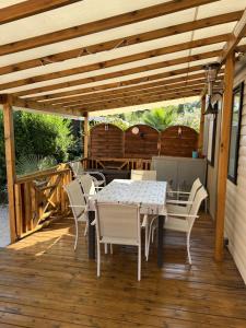 a patio with a table and chairs on a deck at Camping Del Mar 260, Mobile Home Excellence, 3 chambres, 6 personnes, bord de mer in Argelès-sur-Mer