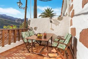 a table and chairs on a balcony with a view at La Escuela de la Sorrueda by Villas Rivero in La Sorrueda