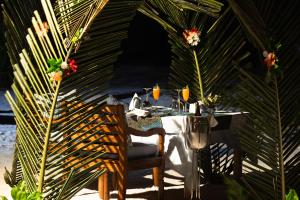 a table with a white table cloth and flowers on it at Kisiwa on the Beach in Paje