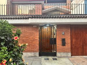 SMiguel, 1P Grande dpto, 4 camas, wifi, lavadora terraza في ليما: مبنى من الطوب مع باب خشبي وشرفة