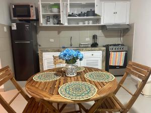 SMiguel, 1P Grande dpto, 4 camas, wifi, lavadora terraza في ليما: مطبخ مع طاولة خشبية عليها زهور زرقاء