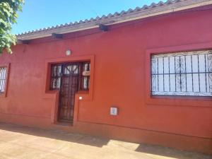 a red building with a door and windows at Casa Quequén in Quequén