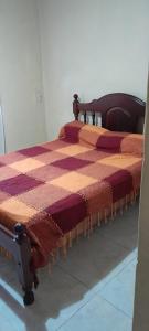 un letto in una stanza con una coperta sopra di Casa Quequén a Quequén Altre 4 foto