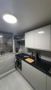 a kitchen with white cabinets and a black counter top at Large Studio for Contractors, Families, Relocation Near New Cross Hospital in Monmore Green