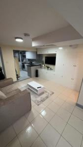 a living room with a couch and a kitchen at Large Studio for Contractors, Families, Relocation Near New Cross Hospital in Monmore Green