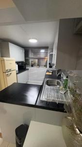 a kitchen with a sink and a dish drying rack at Large Studio for Contractors, Families, Relocation Near New Cross Hospital in Monmore Green +1 photo