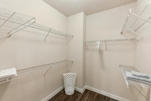 休斯顿Cullen 6103 I New Construction 1bd Apt I Gated的步入式衣柜,配有白色的墙壁和玻璃架子