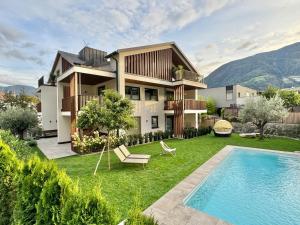 a house with a yard with a swimming pool at Apartsuites Rosengarten in Lagundo
