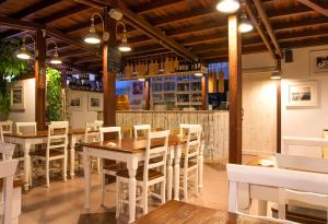 a restaurant with wooden tables and white chairs at Hotel La Villa Del Mare in Cagliari