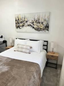 a bedroom with a large white bed with two tables at Affordable Stay Near Proctors A2 in Schenectady