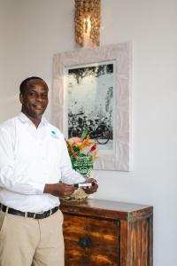 a man standing in front of a table with at Kisiwa on the Beach in Paje