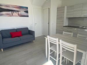 a living room with a couch and a table and chairs at Sirmione - Independent House with Garden in Sirmione