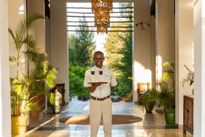 a man standing in a hallway with a plate of food at Kisiwa on the Beach in Paje +37 photos
