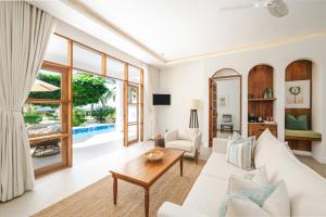 a living room with a white couch and a table at Kisiwa on the Beach in Paje