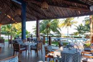 a restaurant with tables and chairs and a view of the ocean at Kisiwa on the Beach in Paje