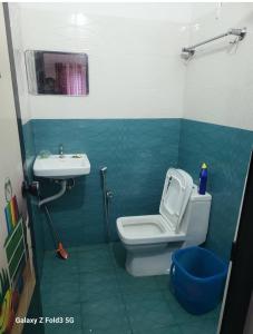a bathroom with a toilet and a sink at Emma Homestay in Pattiyūrgrāmam +39 photos
