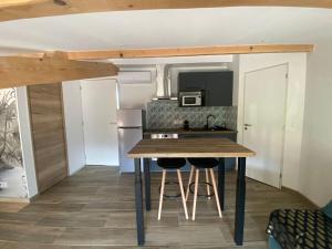 a small kitchen with a table and stools in a room at Gîte La Clé de Saint-Georges in La Roche-de-Glun +3 photos