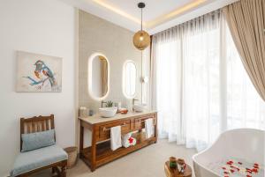 a bathroom with a tub and a sink and a mirror at Kisiwa on the Beach in Paje