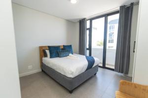 a bedroom with a bed and a large window at Infinite Tide Bellamare in Summerstrand +59 photos