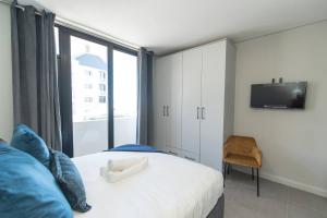 a bedroom with a bed with a tv and a window at Infinite Tide Bellamare in Summerstrand +62 photos