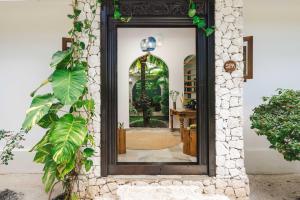 a mirror on the side of a building with plants at Kisiwa on the Beach in Paje