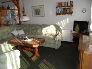 a living room with a couch and a coffee table at Unterm-Reetdach-Whg-5-unten-links in Borkum