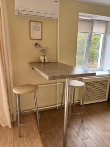 a kitchen with a counter and stools in a room at Квартира в центрі Світлі мрії Avenue Myru35 in Chernihiv