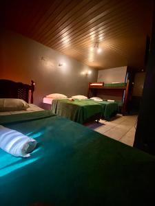 una habitación con dos camas con sábanas verdes en Pousada Portobello, en Recife