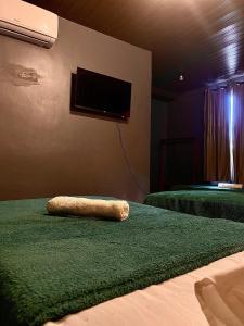 Una habitación con dos camas y un televisor de pantalla plana. en Pousada Portobello, en Recife