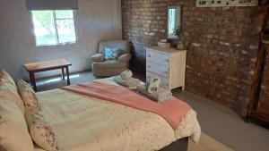 a bedroom with a bed with towels on it at Lentelus-Greeff Cottage in Oudtshoorn