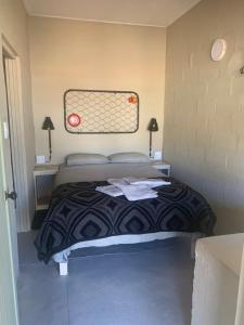 a bedroom with a bed with a black and white comforter at Soebatsfontein Guest Lodge in Soebatsfontein