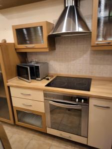 a kitchen with a stove top oven and a microwave at Bell apartment in Klaipėda