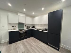 a kitchen with white cabinets and a black refrigerator at Kinzo's Apartment in Chatham +27 photos